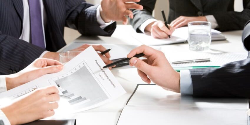 Close-up of businessman explaining a financial plan to colleagues at meeting